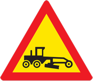 A grader is working on the carriageway ahead